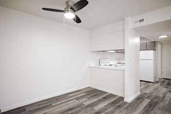 an empty living room with a kitchen and a ceiling fan at Summit, Pocatello, ID 83201